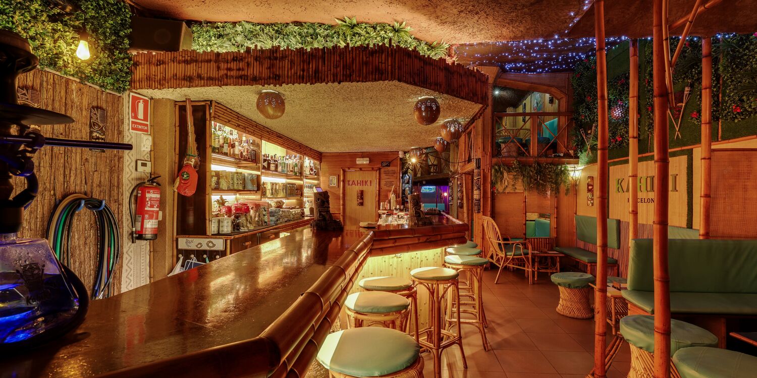 Barra completa de Kahiki Barcelona con estanterías de licores y luces cálidas